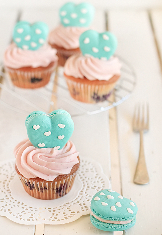 Vanilla Bean Blueberry Cupcakes with a Heart Macaron Topper from Raspberri Cupcakes via The TomKat Studio.